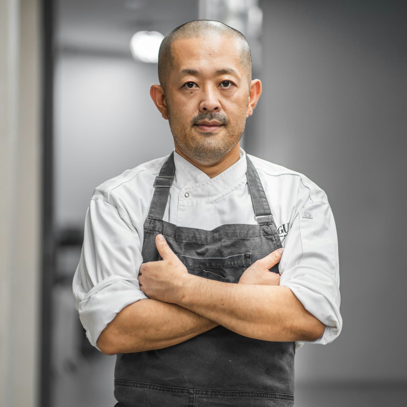 A chef at the pass, plating under warm kitchen light