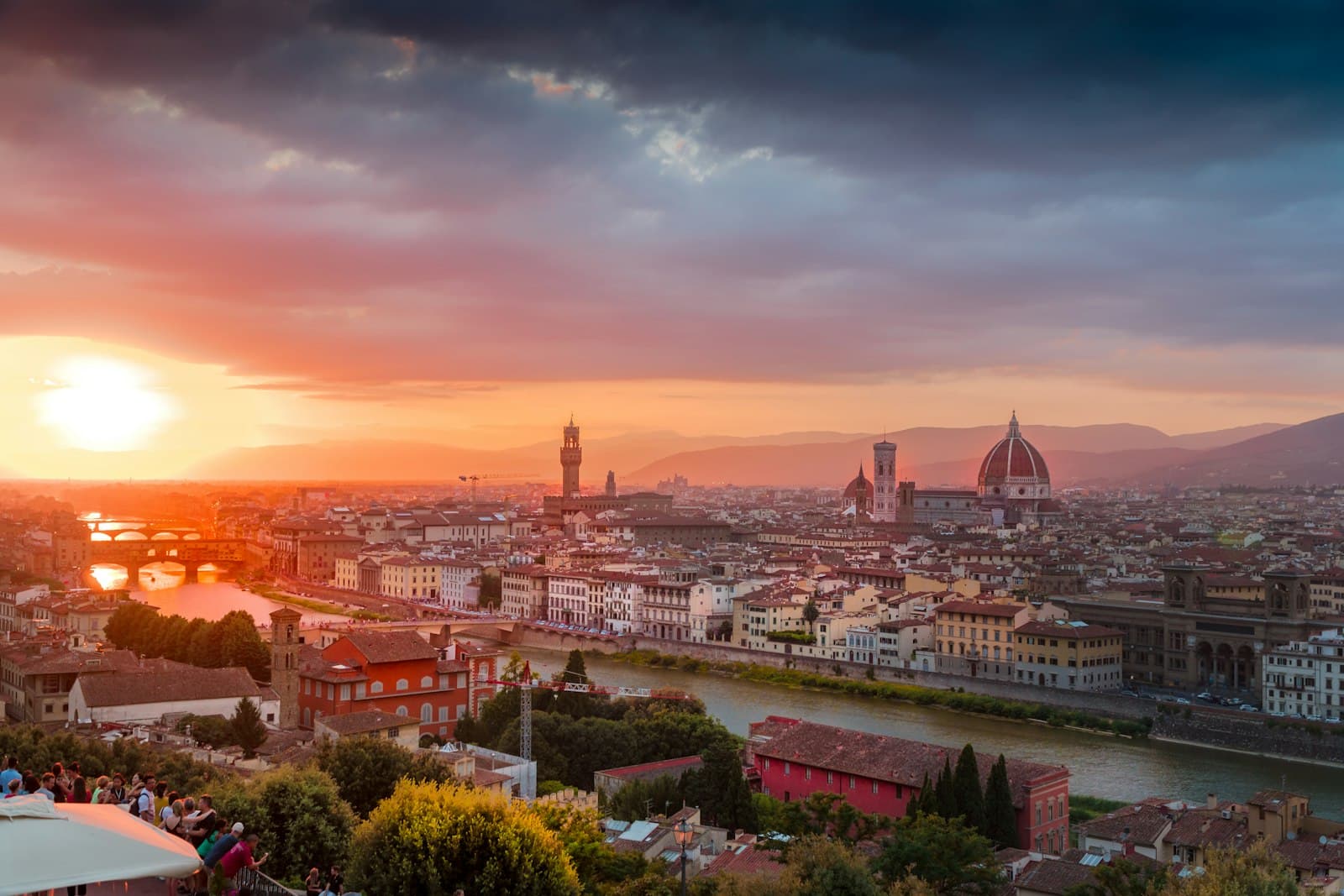The Duomo of Florence rising over terracotta rooftops at dusk