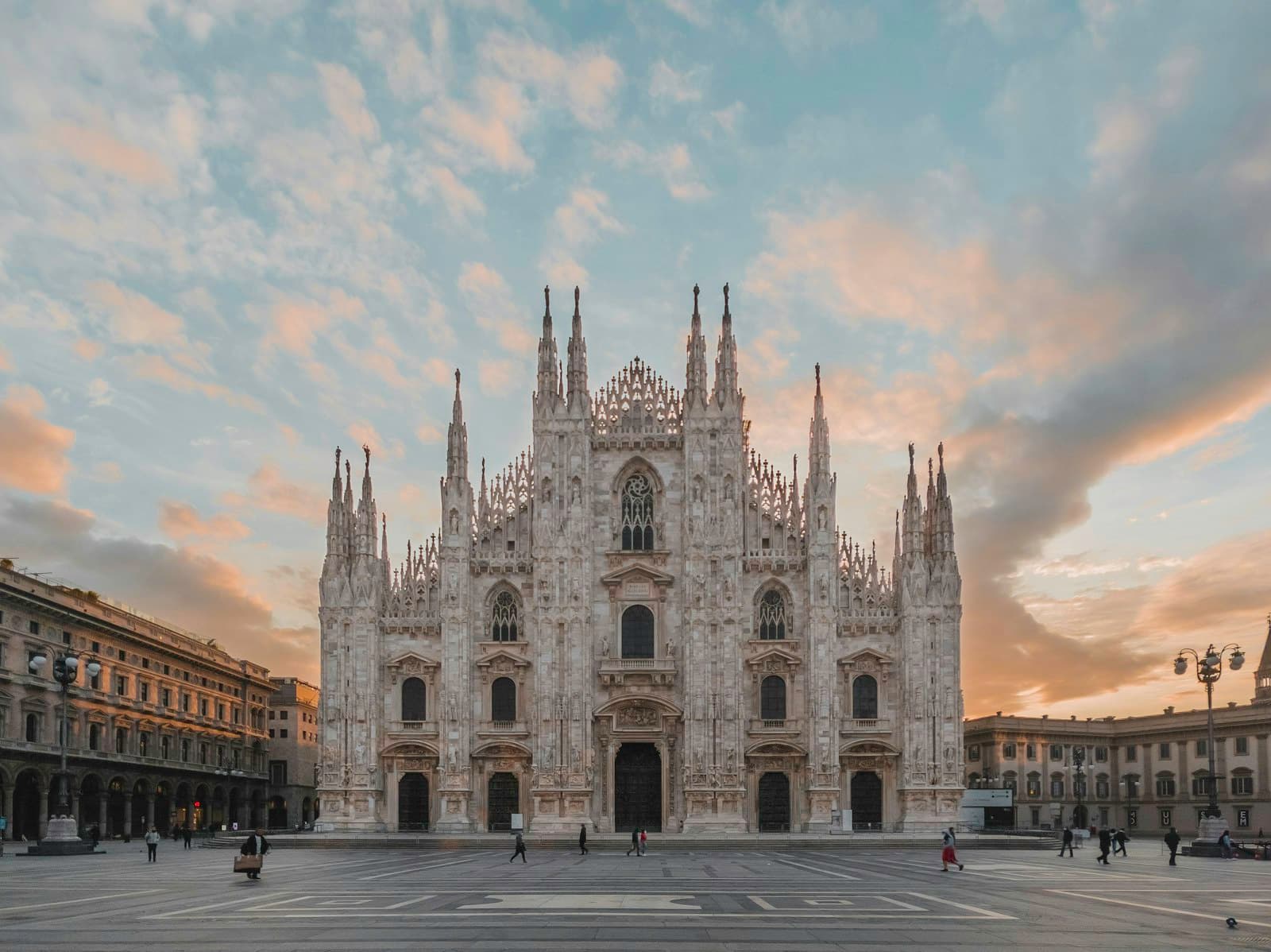 The spires of the Milan Duomo against an evening sky